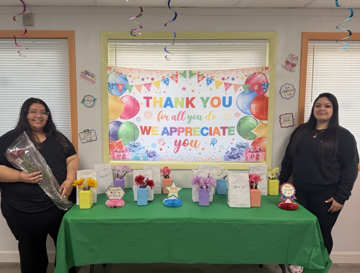 Staff with flowers beside the appreciation table